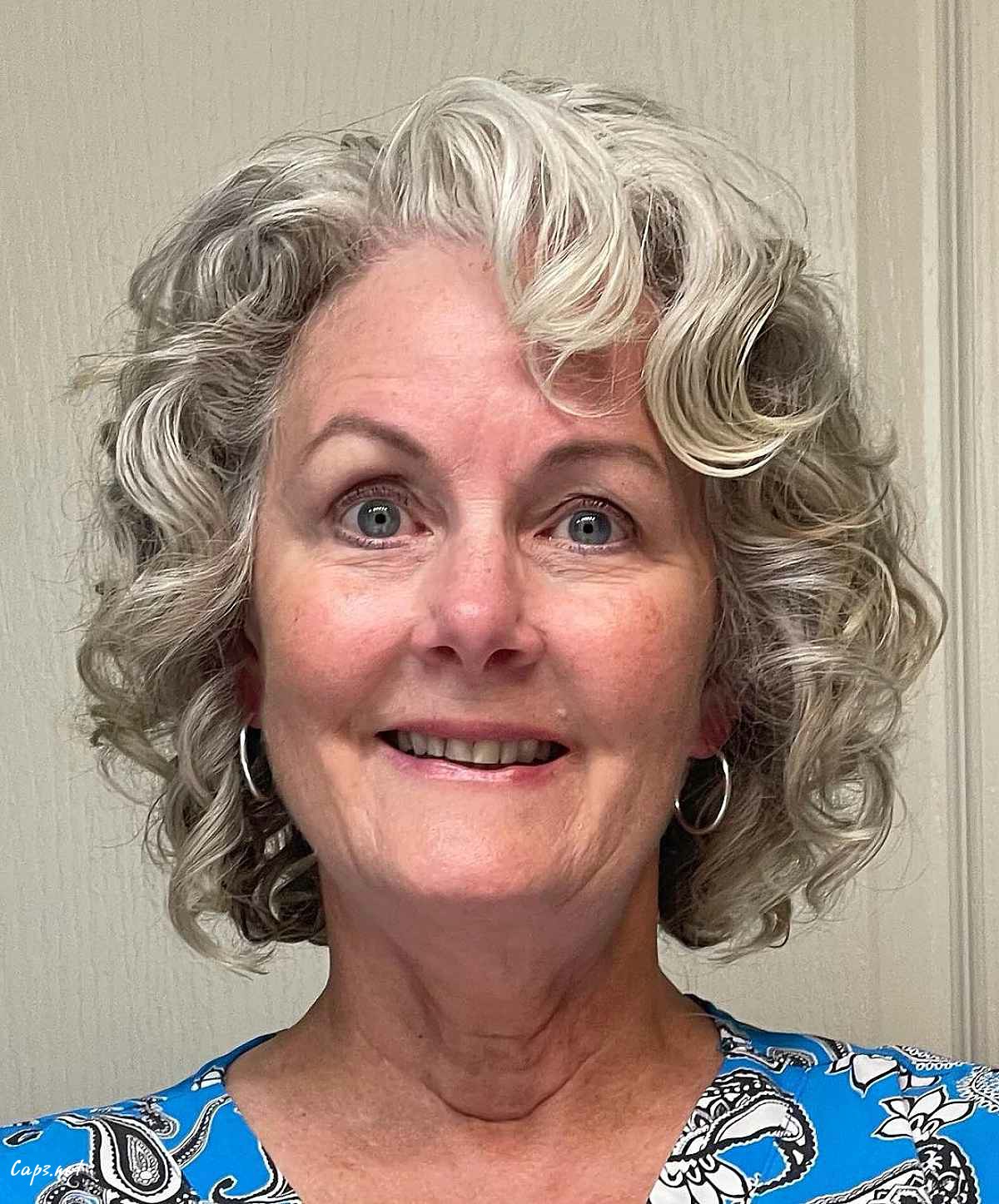 short rounded cut a woman over 60 with curly hair
