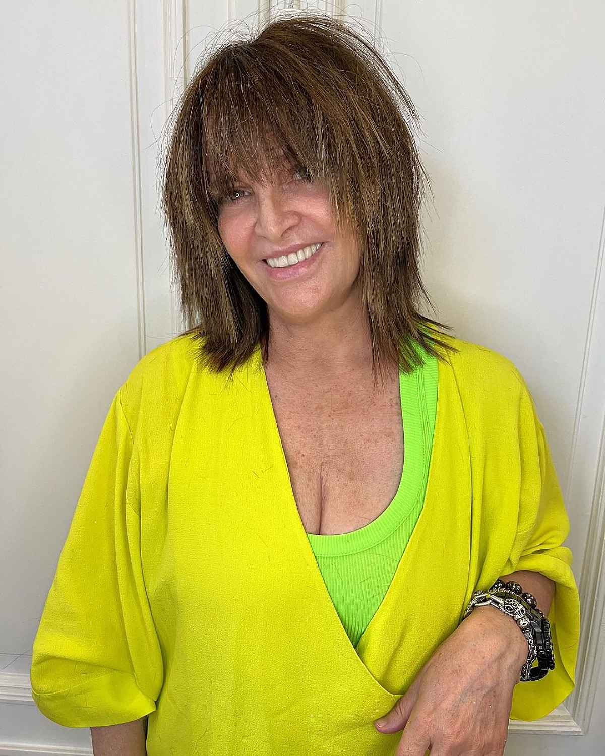 medium shag with choppy layers and bangs for women 60 and up