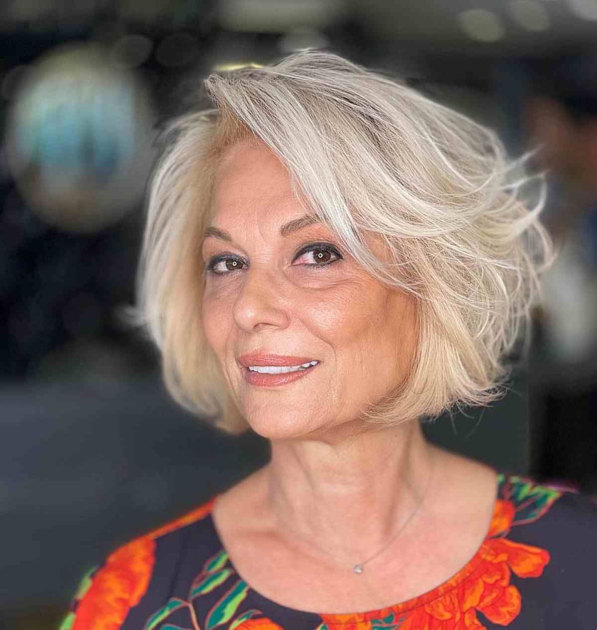 short feathered bob with a side part for women 60 and over