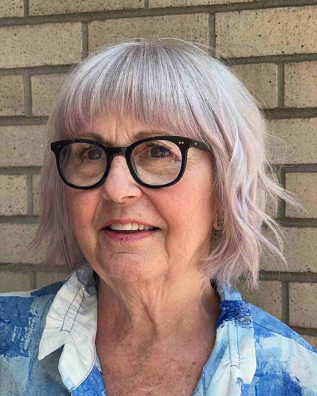 textured bob hairstyle with short bangs for a lady in her 60s