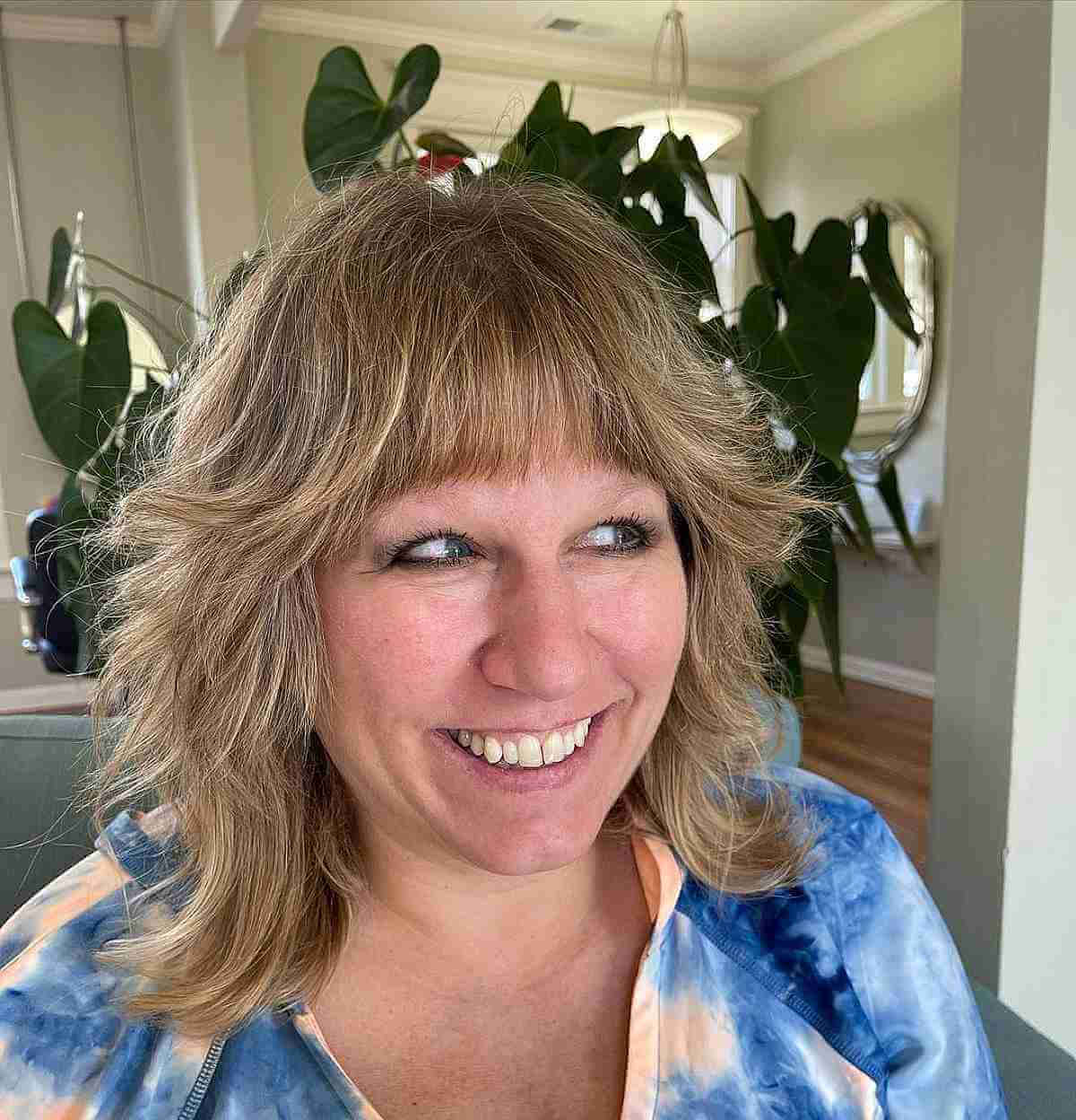 textured wolf cut with blunt bangs for ladies 40 and over