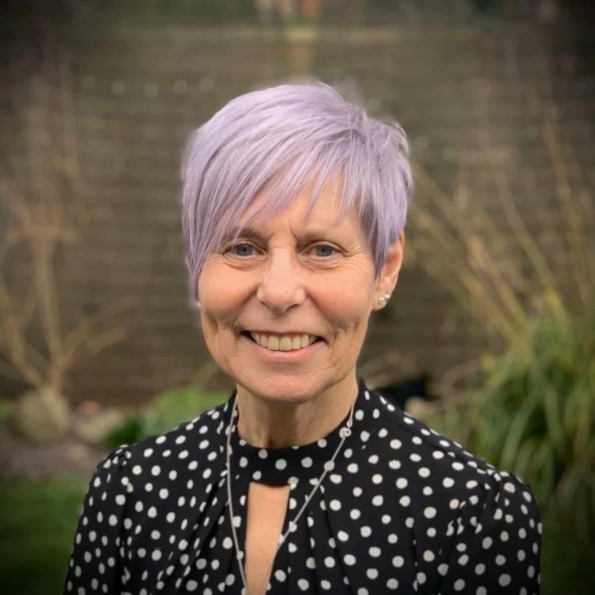 woman over 60 with a purple pixie and bangs