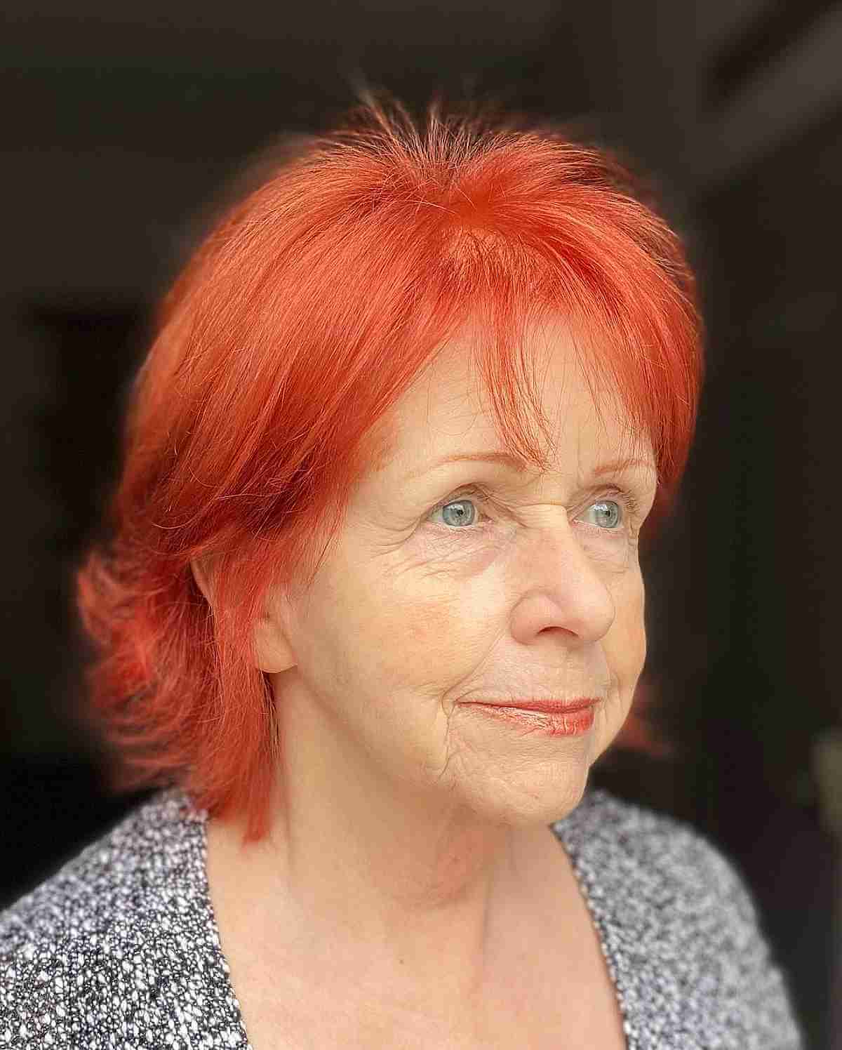 bright copper red hair with wispy bangs for ladies in their 70s
