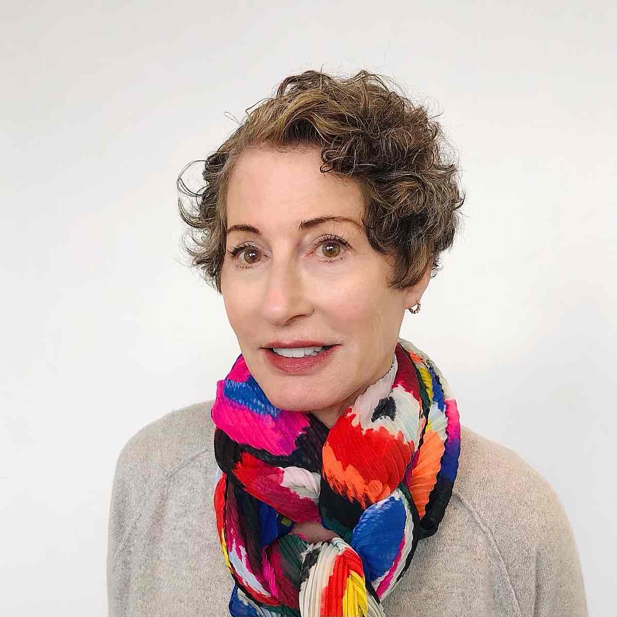 extra short curly hairstyle with a deep side part for 60 year olds