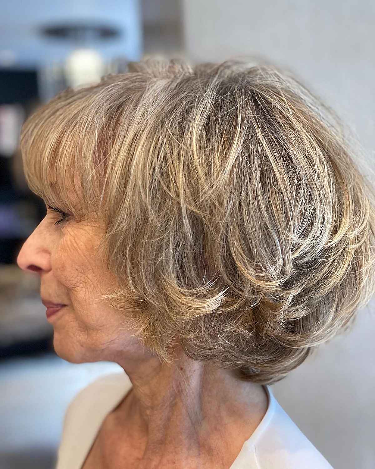 feathered bob with wispy bangs for women 60 and over
