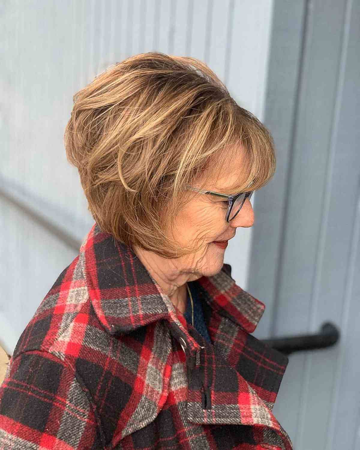 feathered wedge bob with wispy bangs for a lady in her 70s