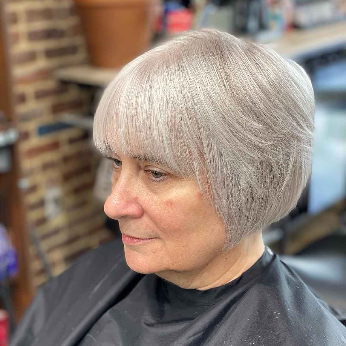 grey angled bob with wispy bangs for ladies past sixty