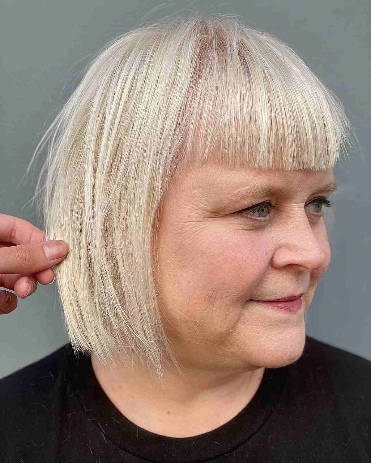 lady over 50 with short blunt cut bold blunt bangs