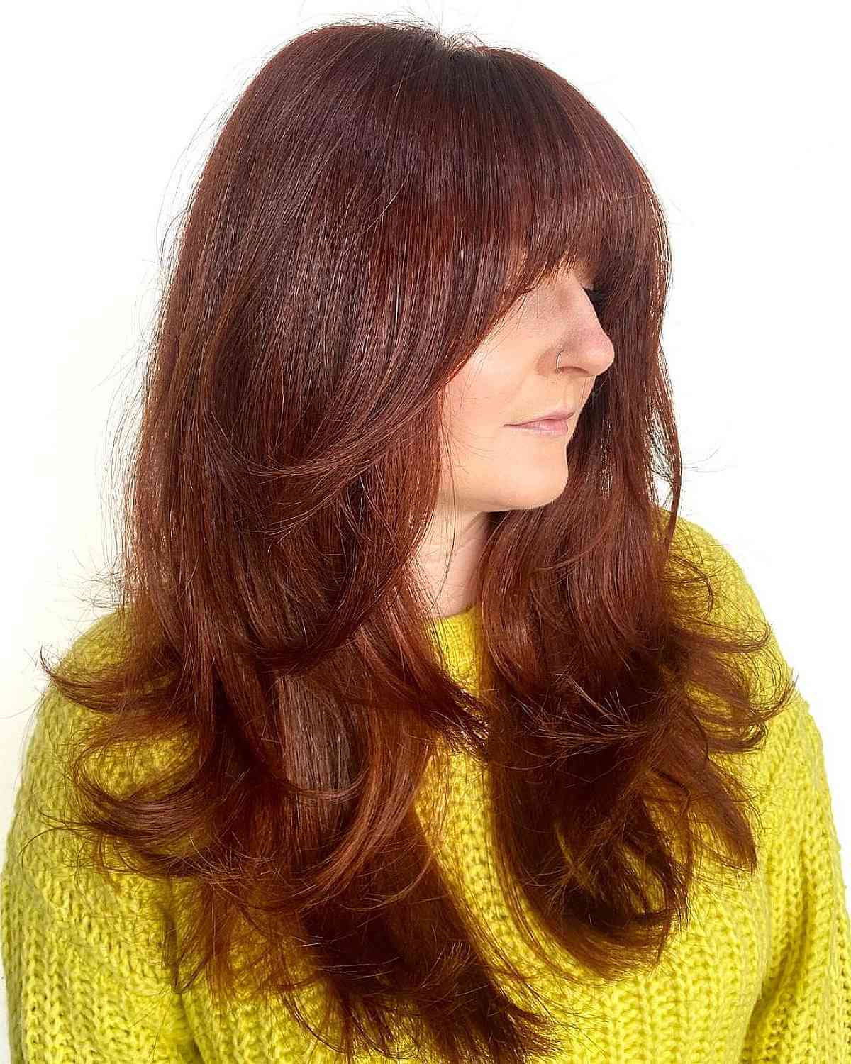 long blowout style on a layered cut with bangs for a 40 year old lady
