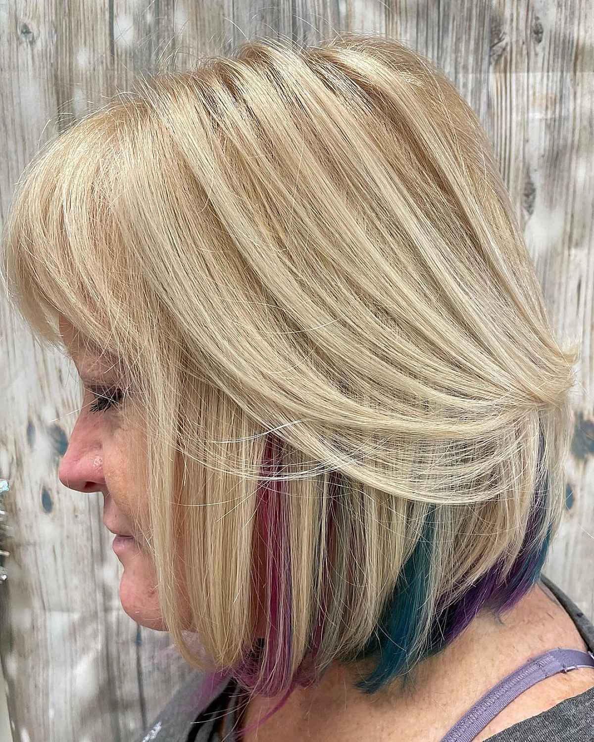 medium layered bob with peek a boo highlights for women in their sixties