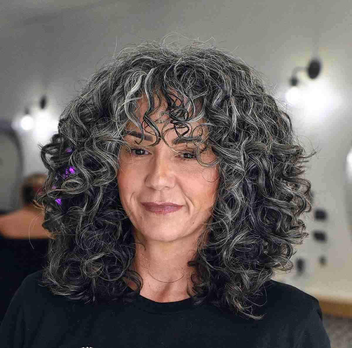 medium length salt and pepper curly bob with curly bangs for ladies 60 and up