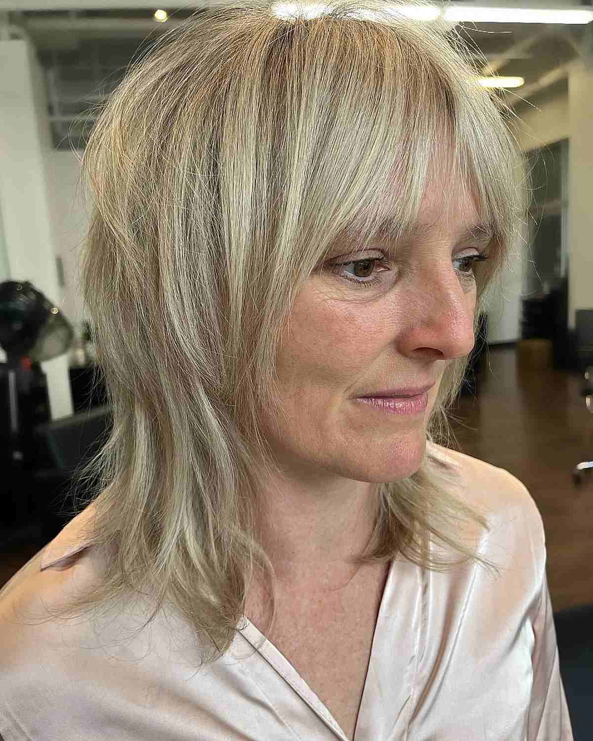 medium length straight choppy wolf cut and curtain bangs for a 60 year old