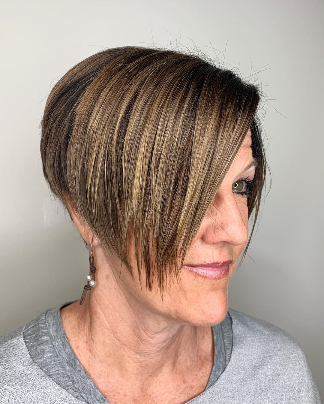 pixie haircut with side swept bangs for women aged 50 to look younger