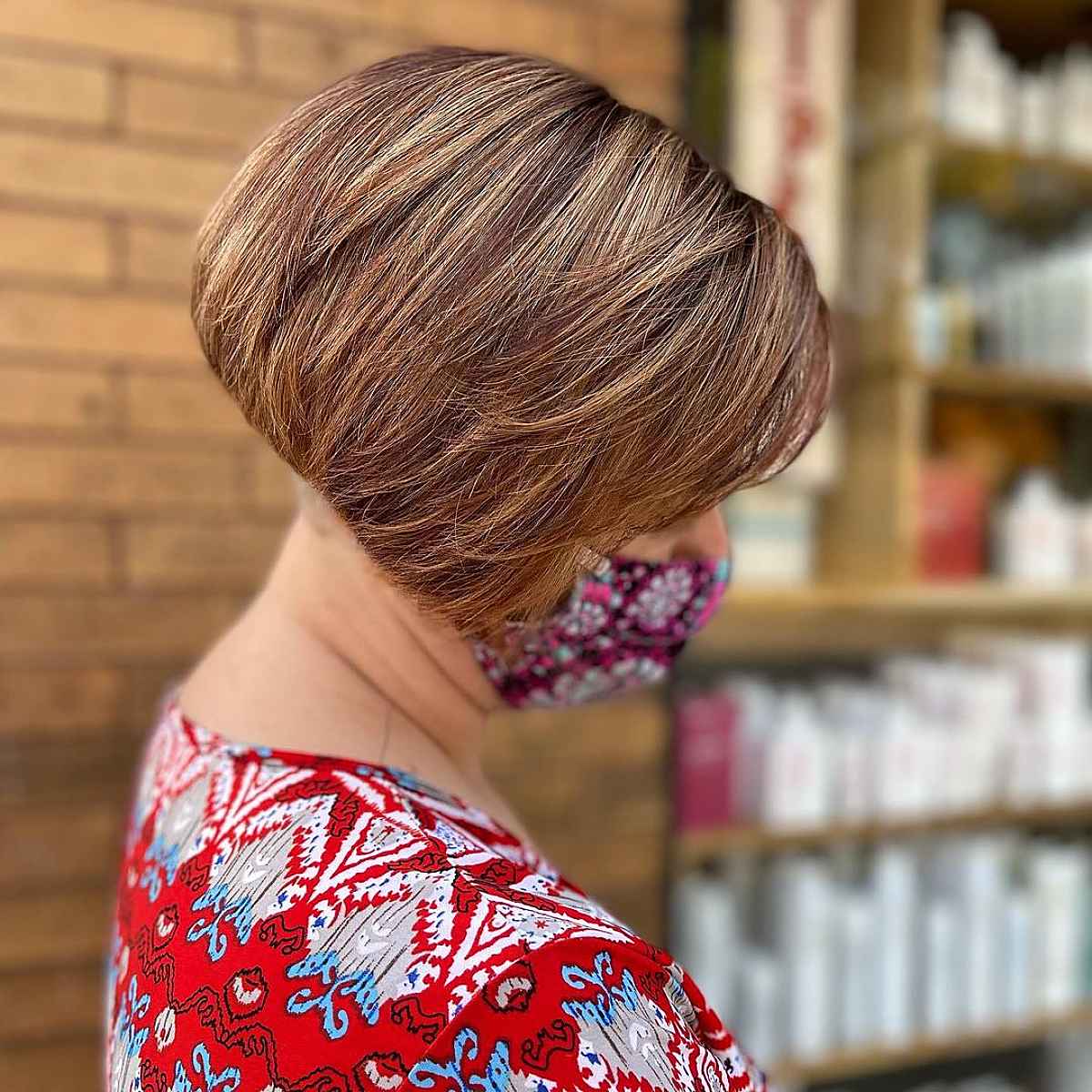 short inverted bob with reddish brown and caramel highlights for ladies over 60