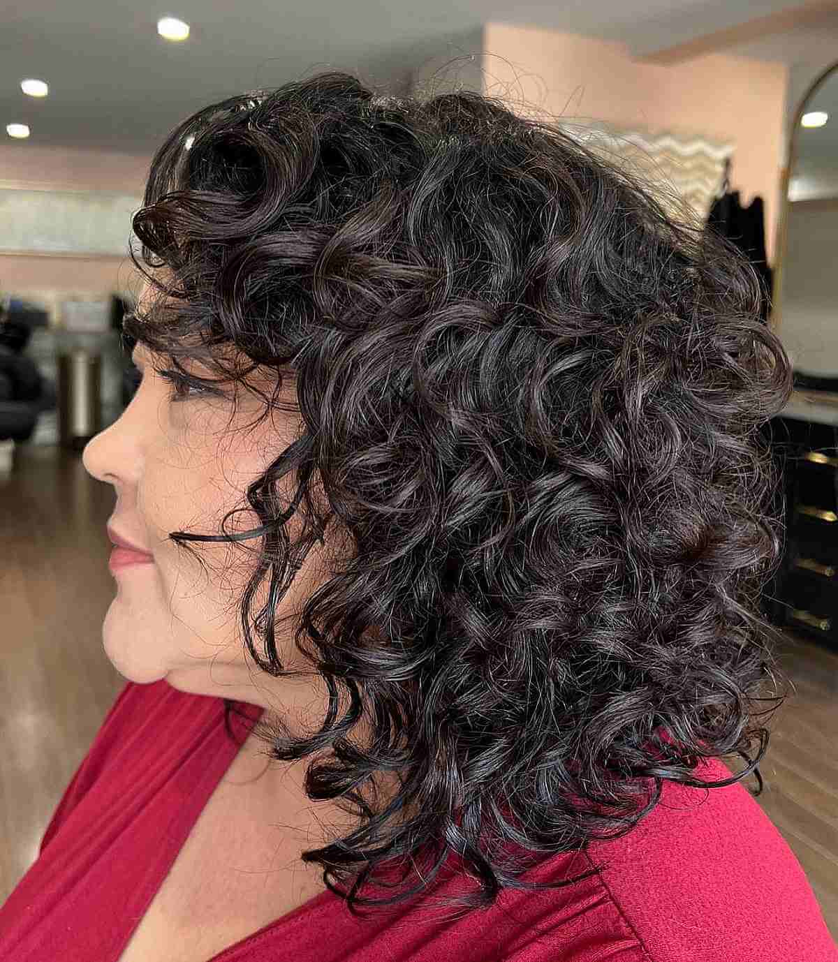 shoulder length curly haircut with curly bangs for an old lady