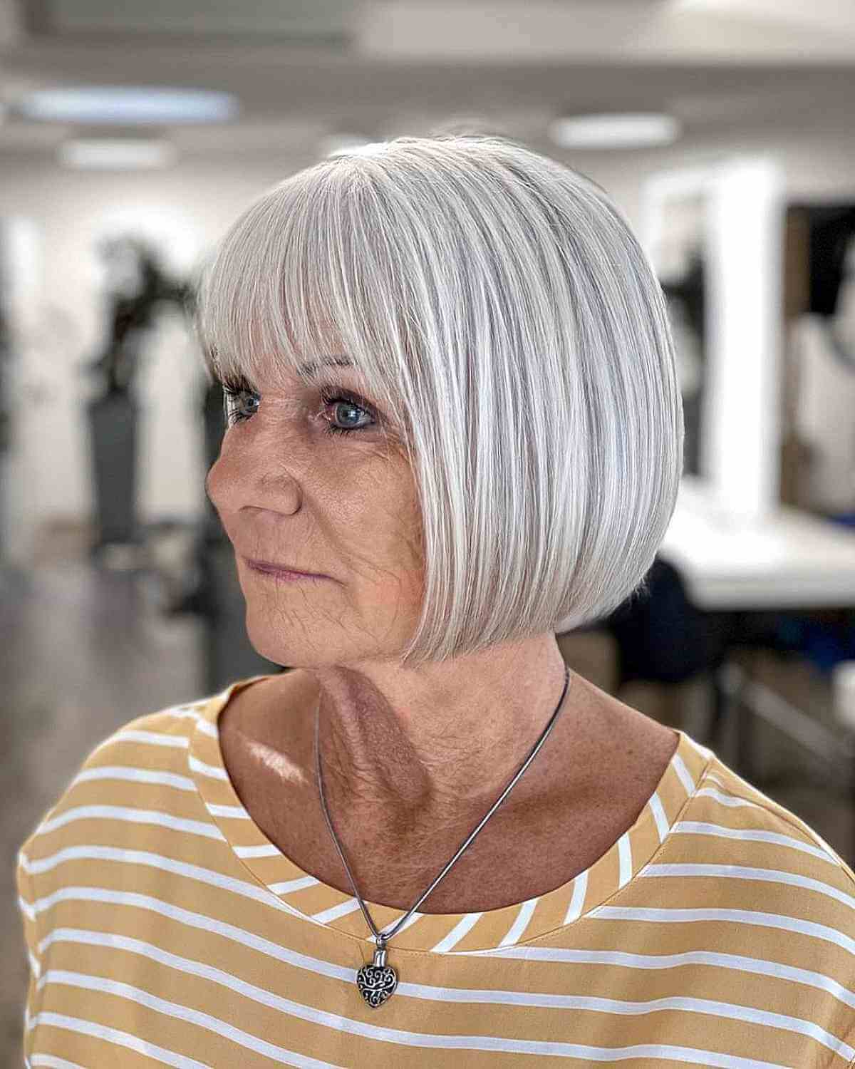 soft gray bob with wispy bangs for ladies 70 and up