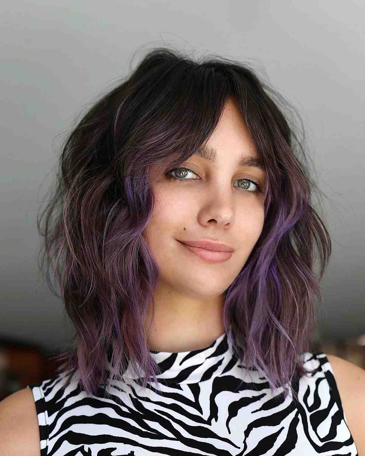 textured layered lob with purple highlights and curtain bangs