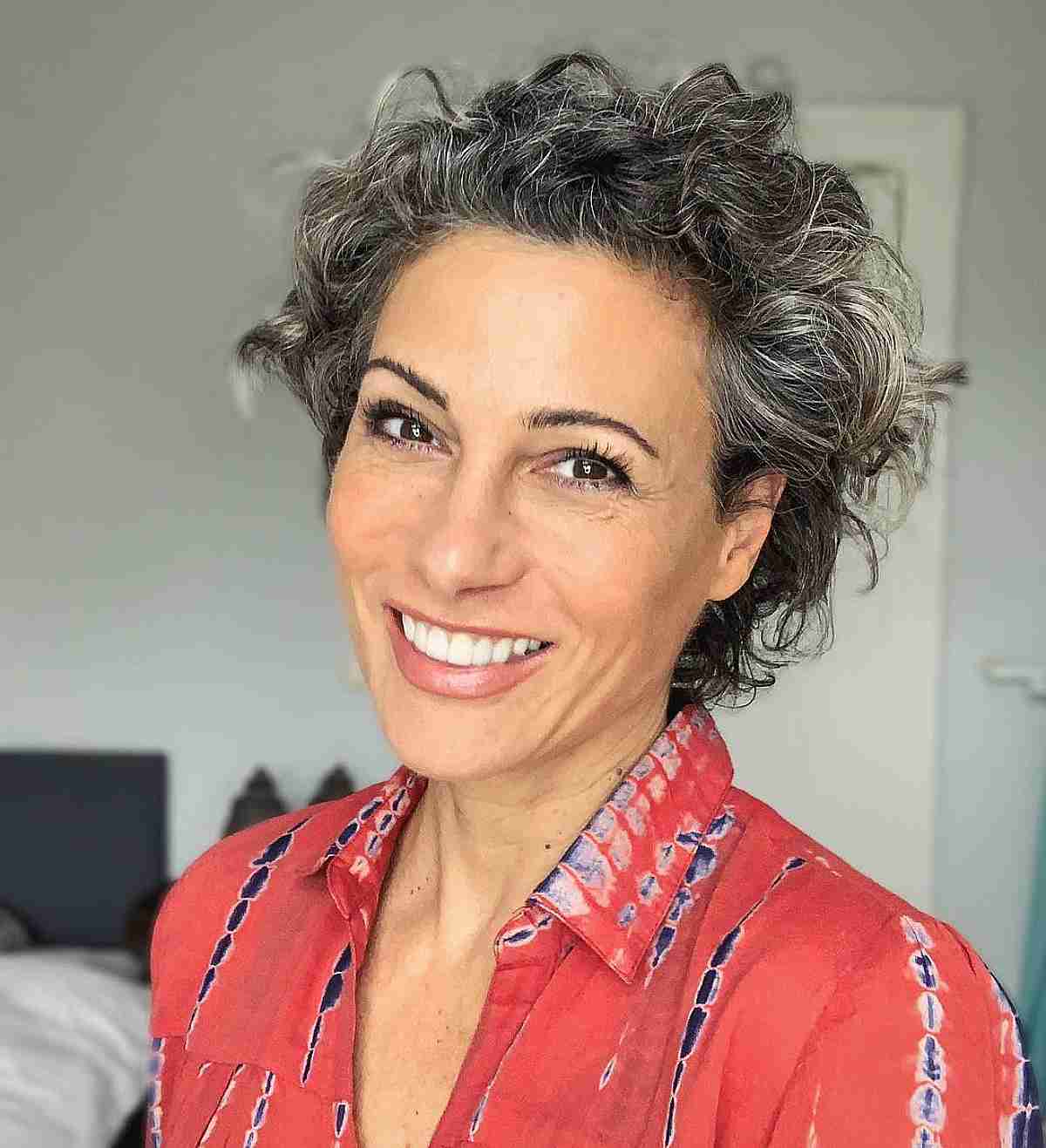 very short curly cut on salt and pepper hair for women over 50