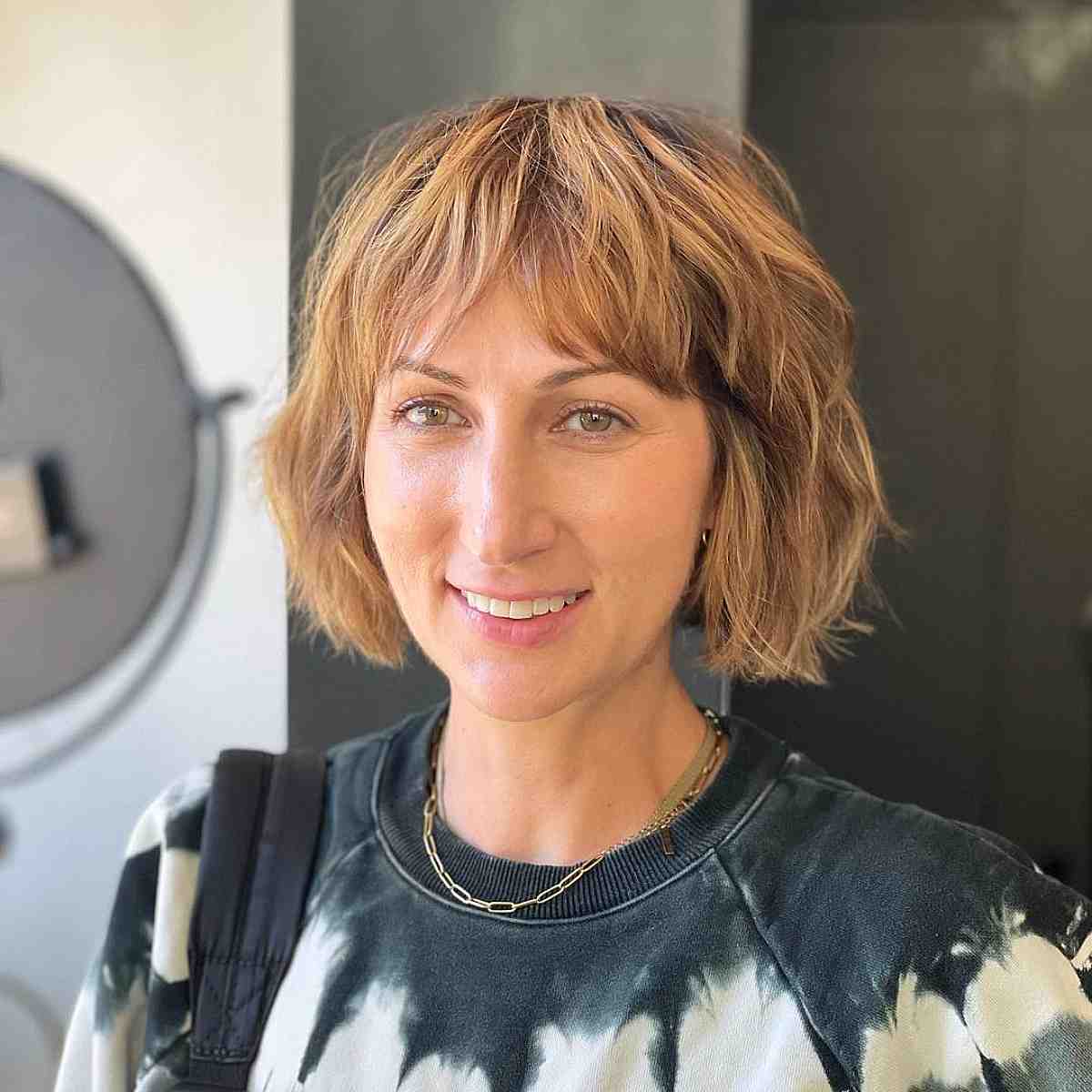 blonde balayage on a textured layered bob with bangs