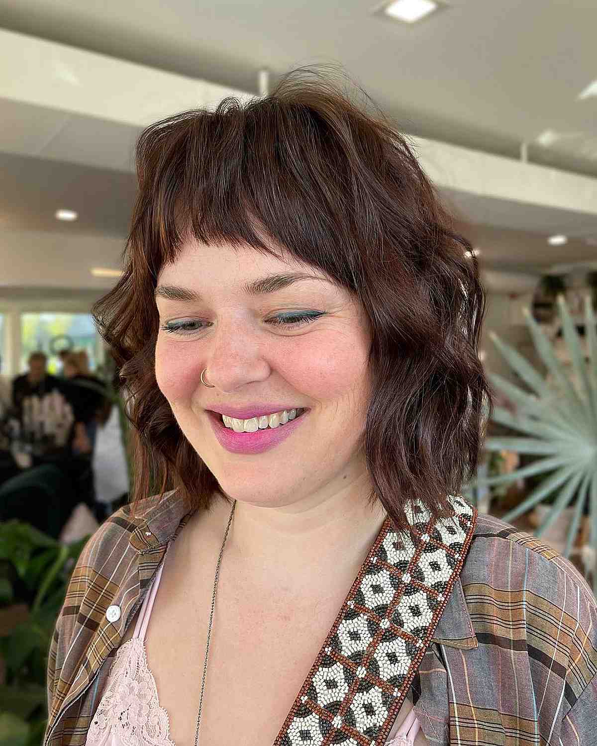 brunette textured wavy bob with short arched bangs