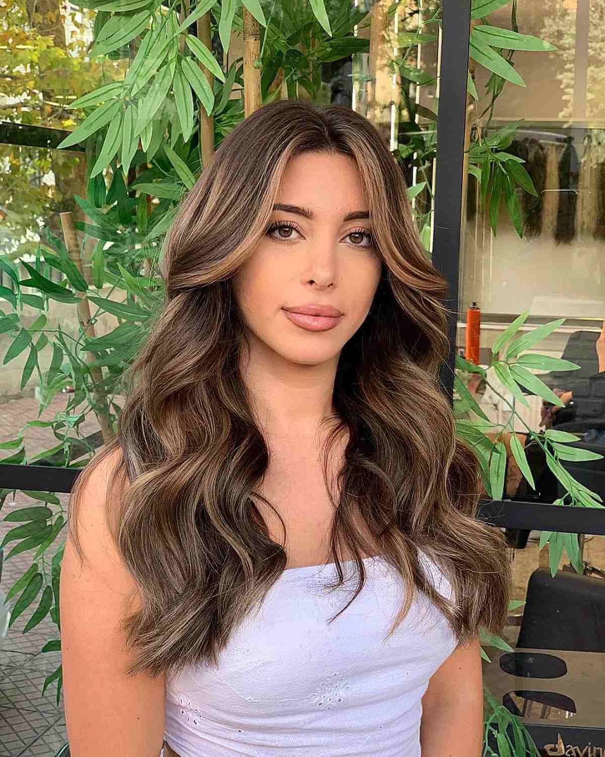 center parted long hair with voluminous waves for oval faces