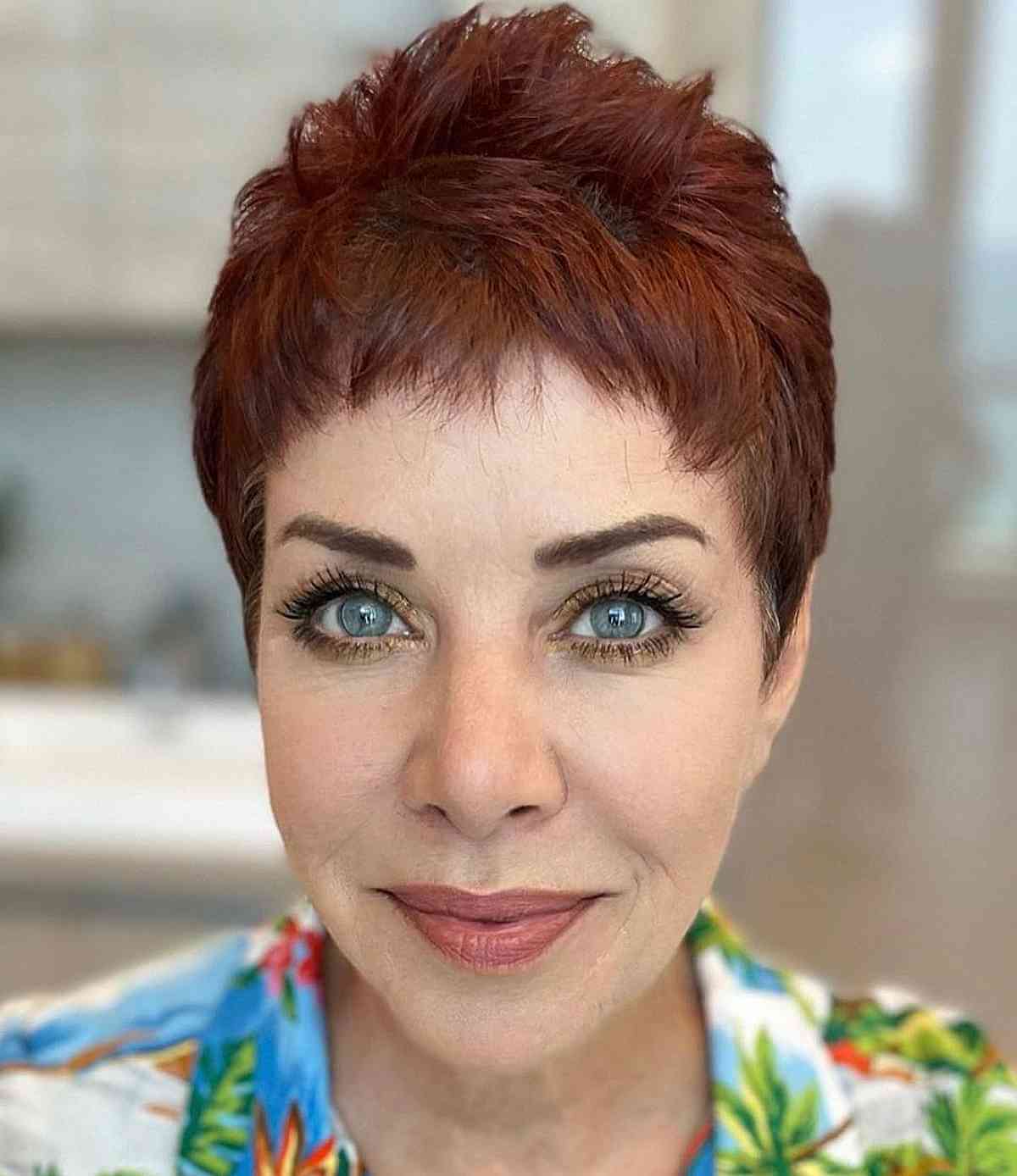 cute red pixie with baby bangs for ladies over fifty with thin hair