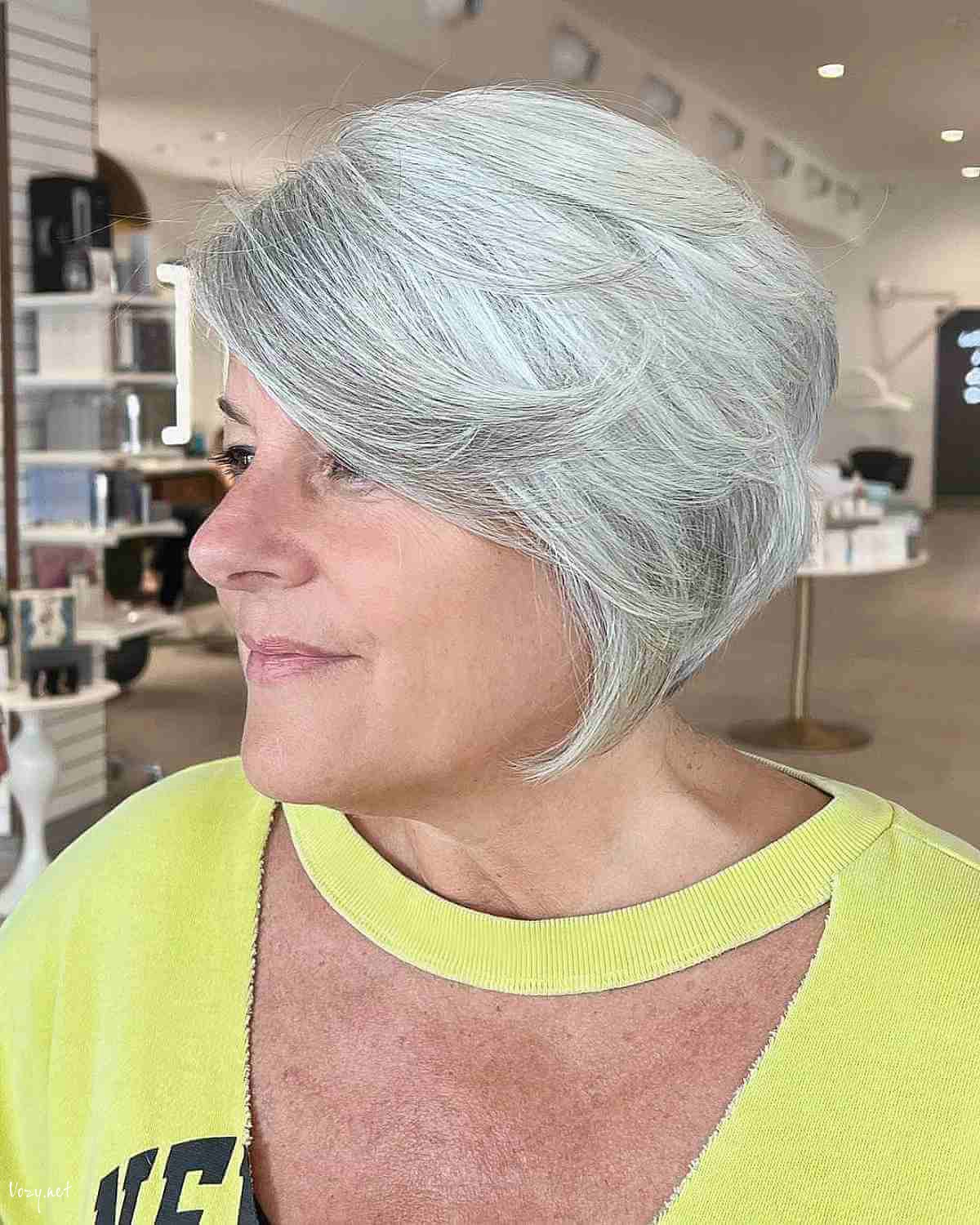 feathered silver bob with side swept bangs for women 50 and over