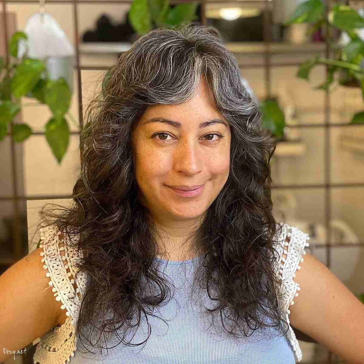 greying curly shag haircut for women over fifty with round faces