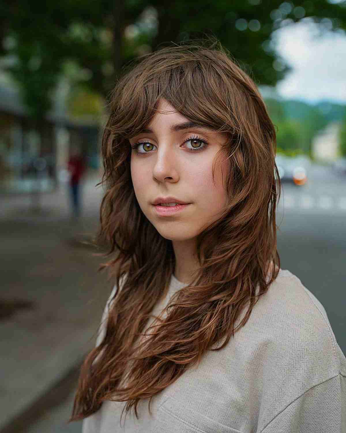 heavily layered shaggy cut with curtain bangs for oval face shapes