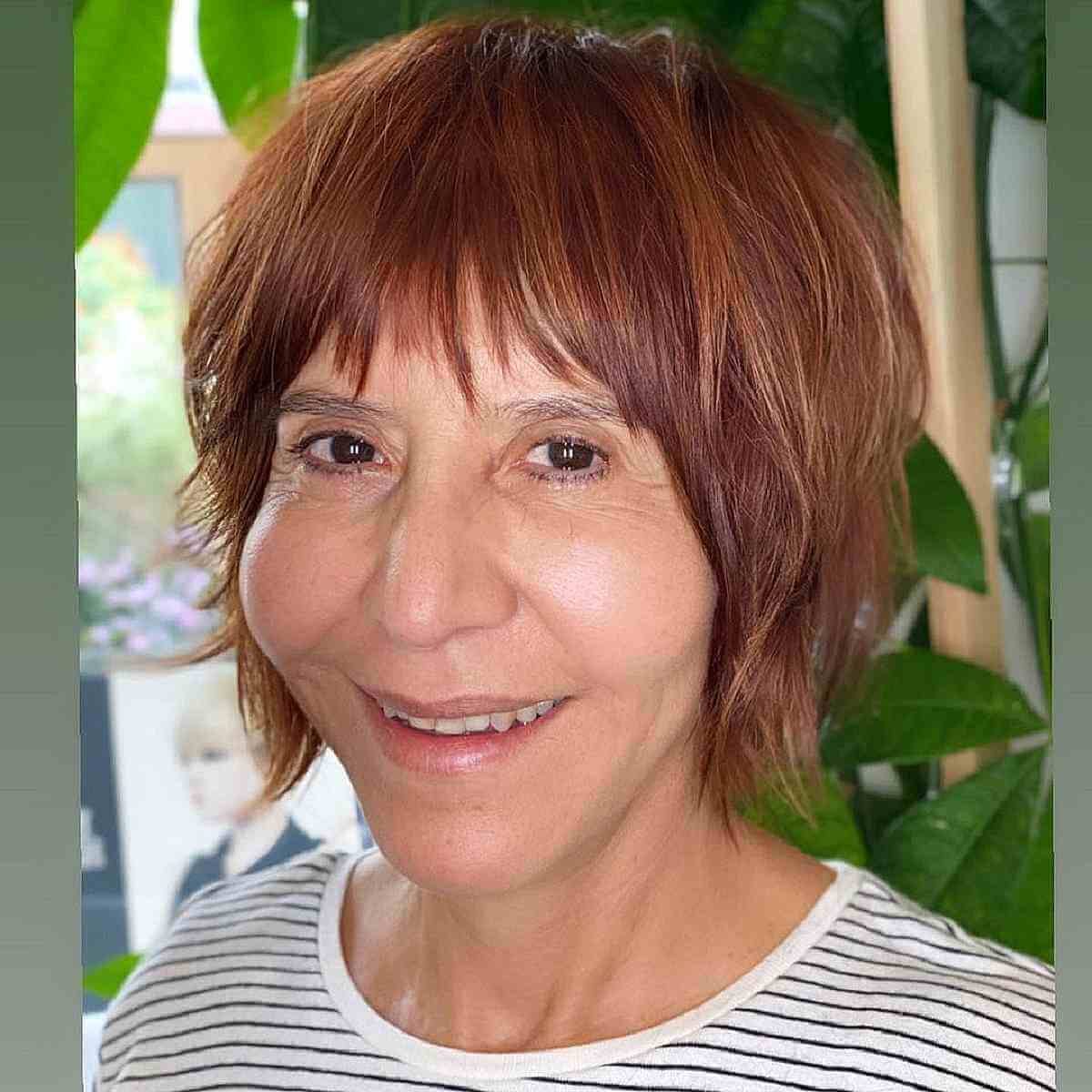 layered bob cut with textured bangs for women over 50