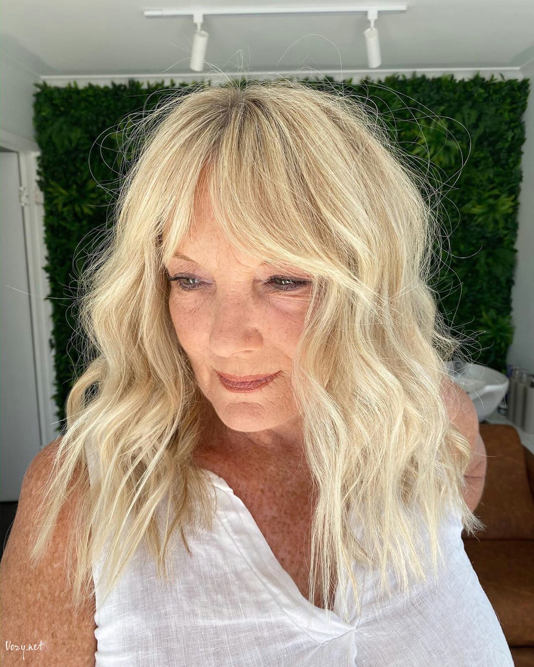long hairstyle with curtain bangs for ladies in their 50s