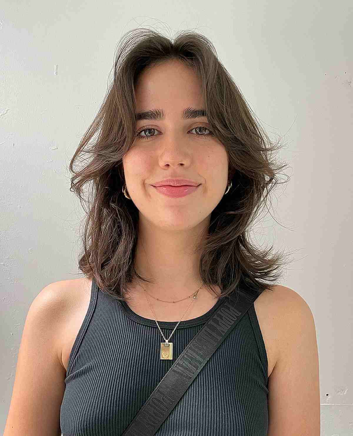 medium face framing haircut with natural waves for an oval face