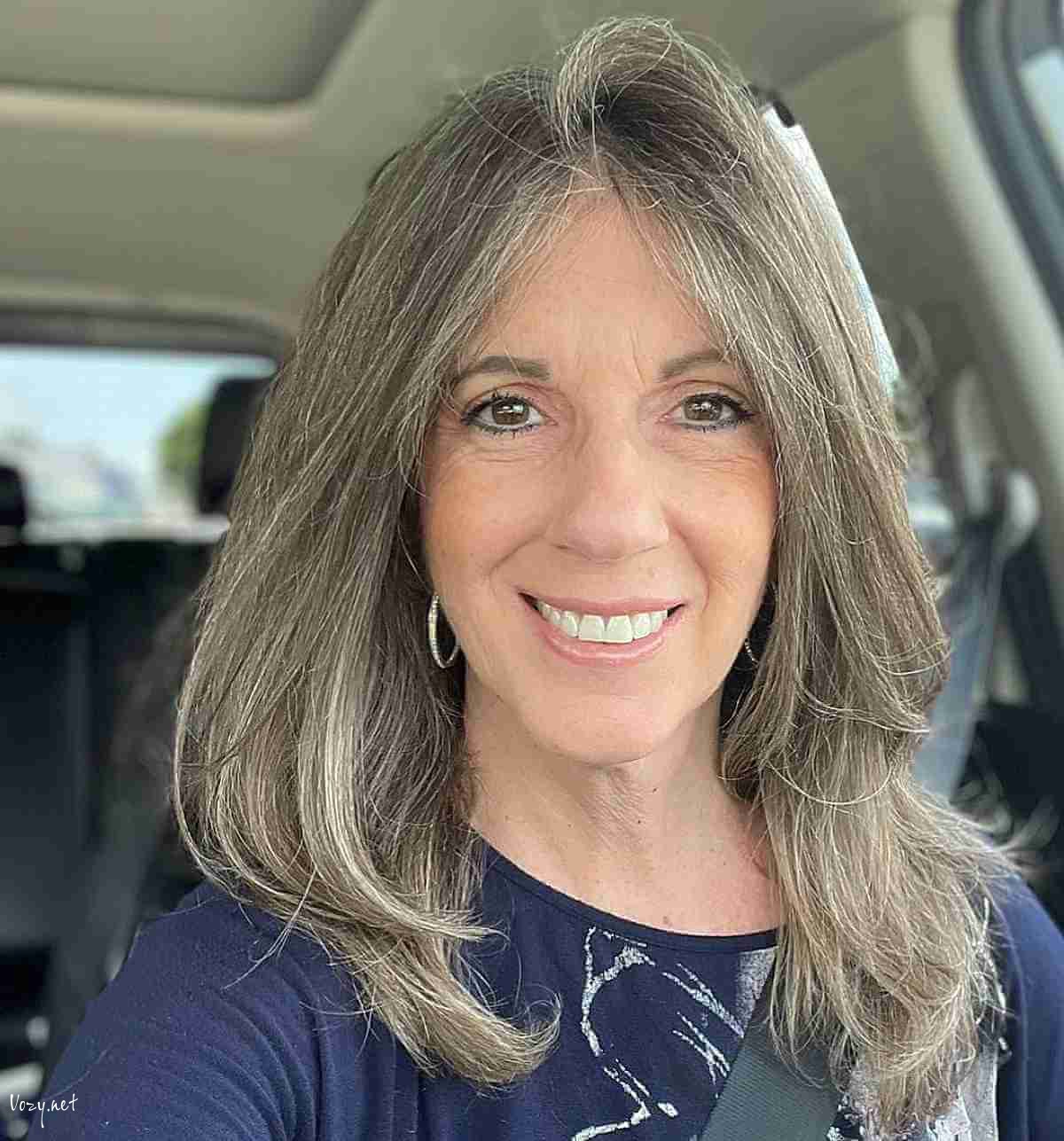 middle parted medium haircut with long layers for ladies 50 and up