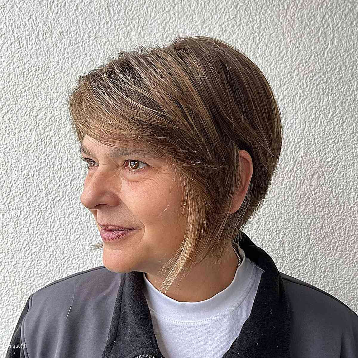 shaggy bob with side swept bangs for women in their 50s with round faces