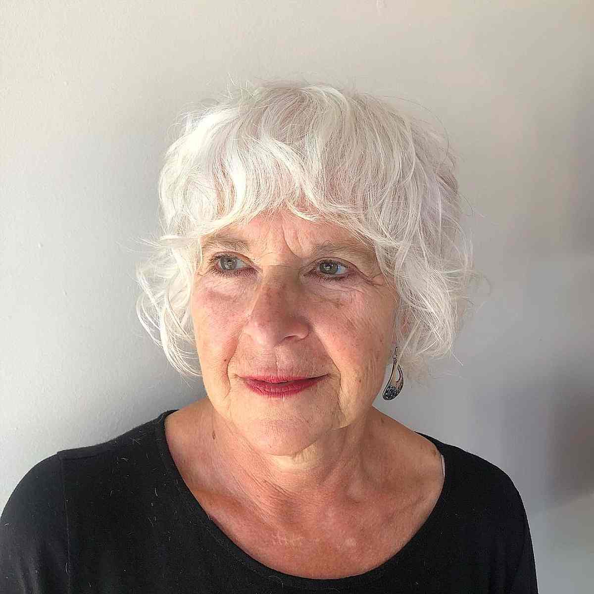 short face framing shag with wavy bangs for women over 70