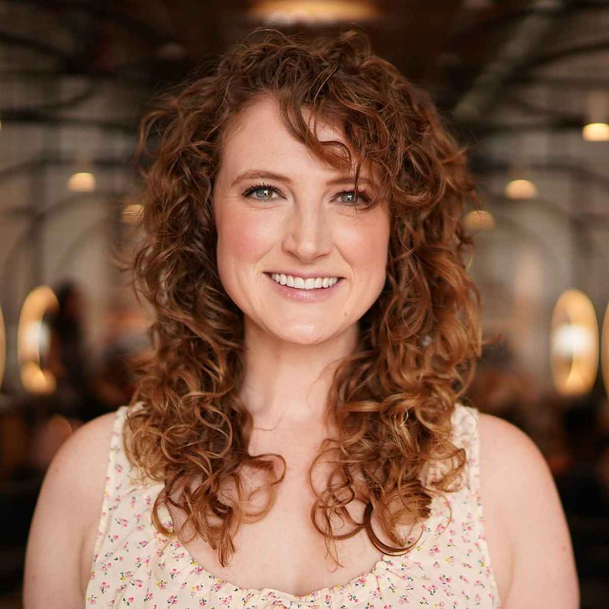 shoulder length curly hairstyle with side bangs