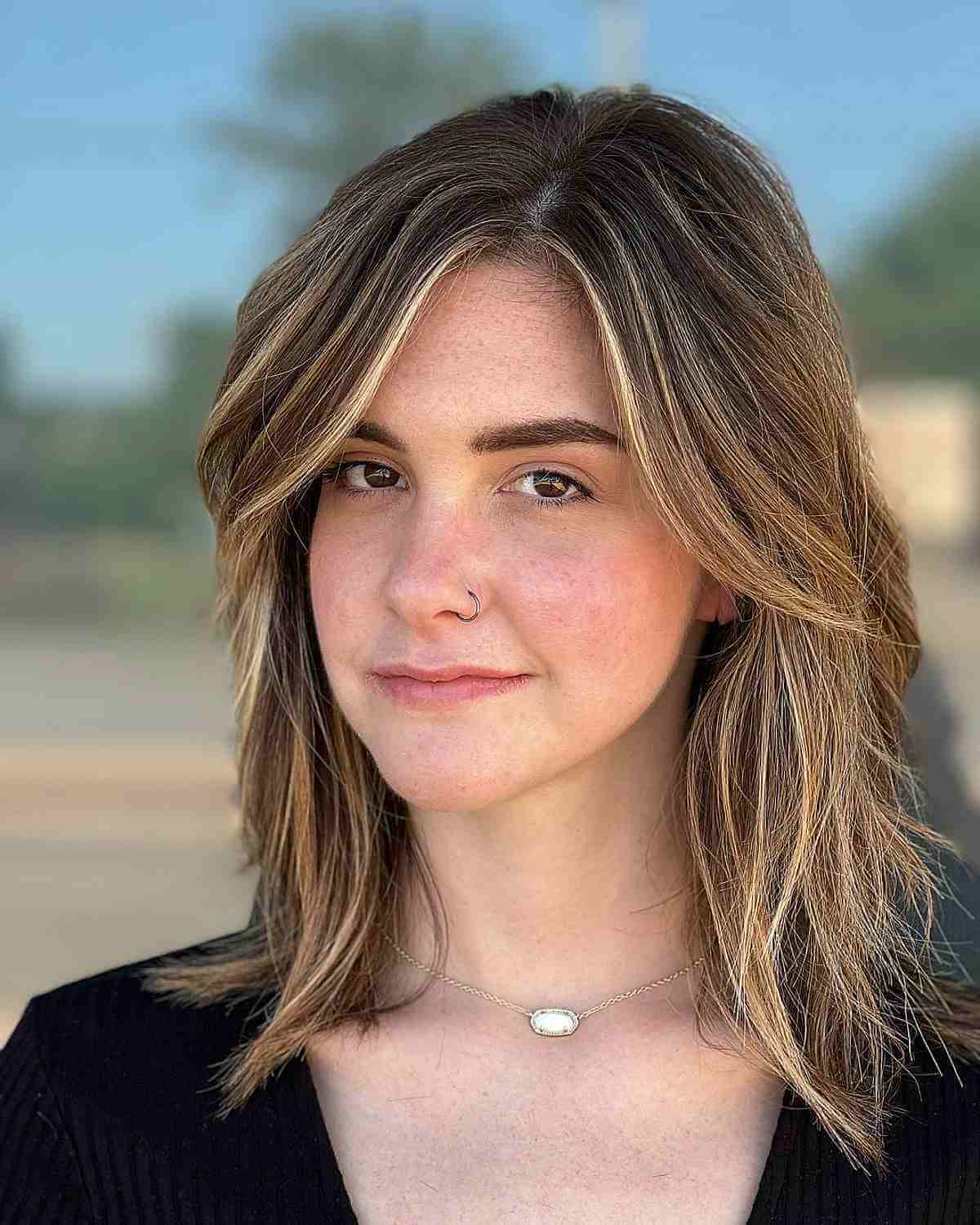 side parted choppy haircut with a money piece for an oval face