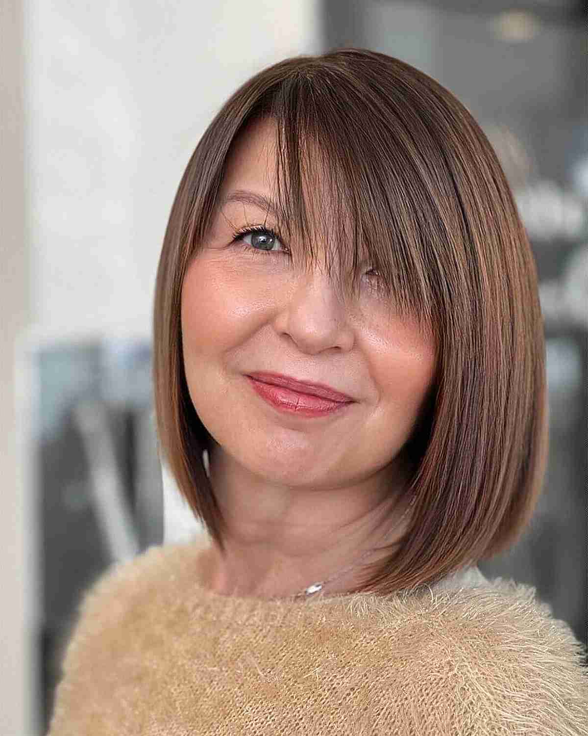 side swept fringe on a chic bob cut for 50 year olds with fine hair