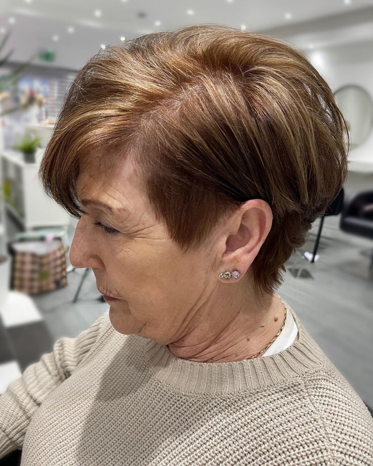 tousled pixie bob with a shaved side for older women