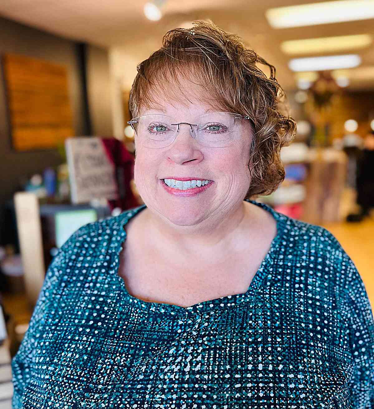 curly asymmetrical bob and wispy bangs for older women over 60 round face shapes