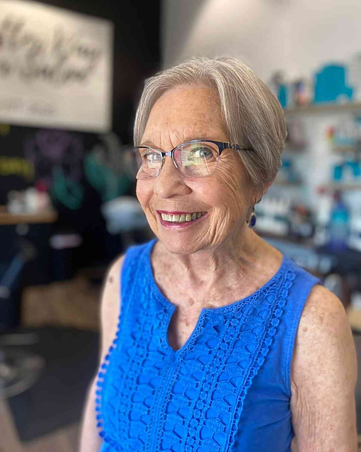 face framing silver pixie for seniors over 60 with a pair of glasses