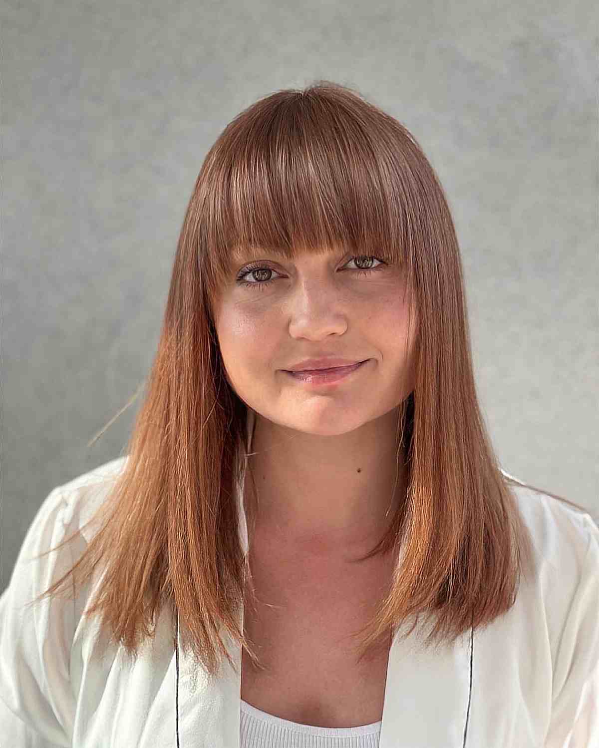 mid length straight hair with textured ends and full fringe