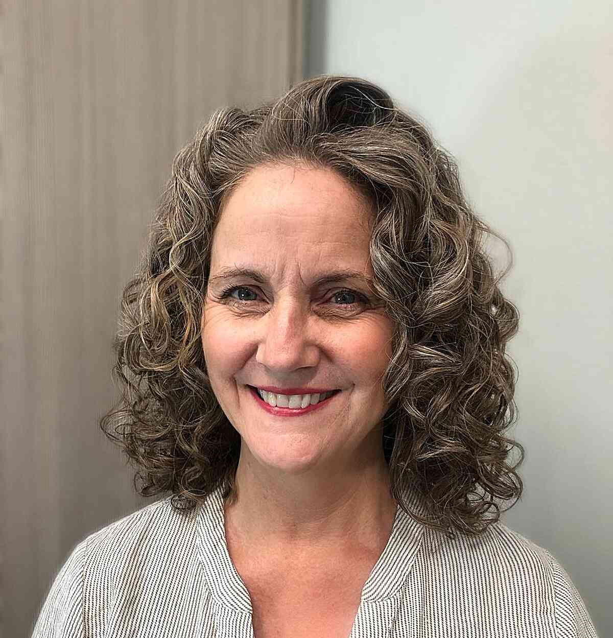 mid length voluminous curls with face frame on mature ladies past sixty