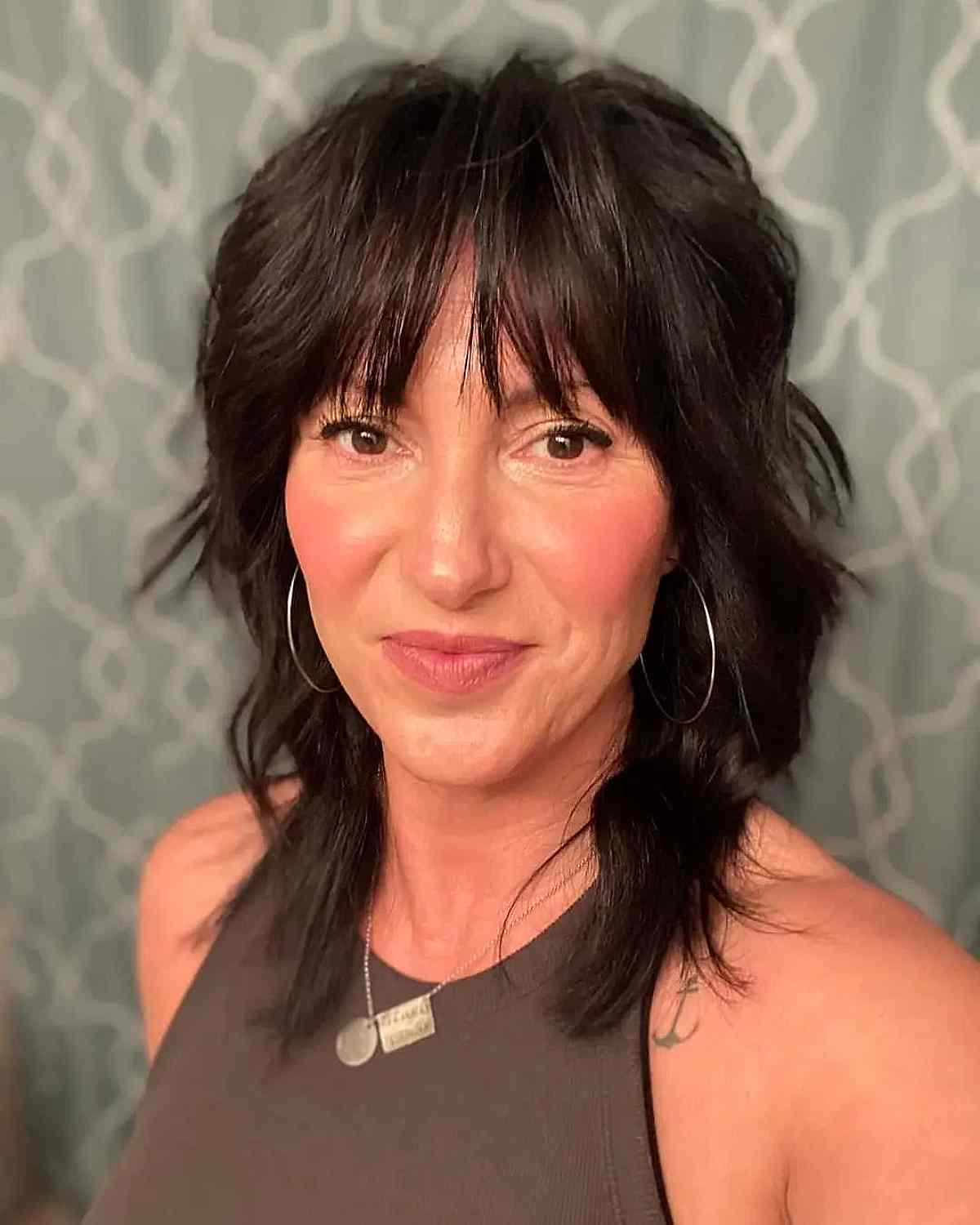 modern mullet shag with piece y bangs for ladies in their forties