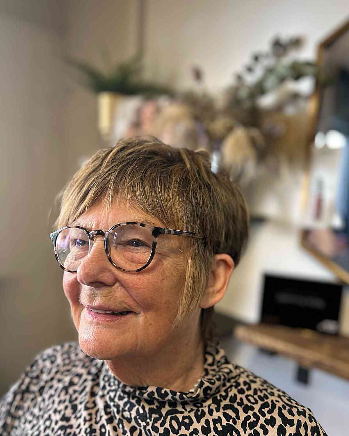 short hair with soft shag pixie cut and curtain bangs for women over 60 with glasses