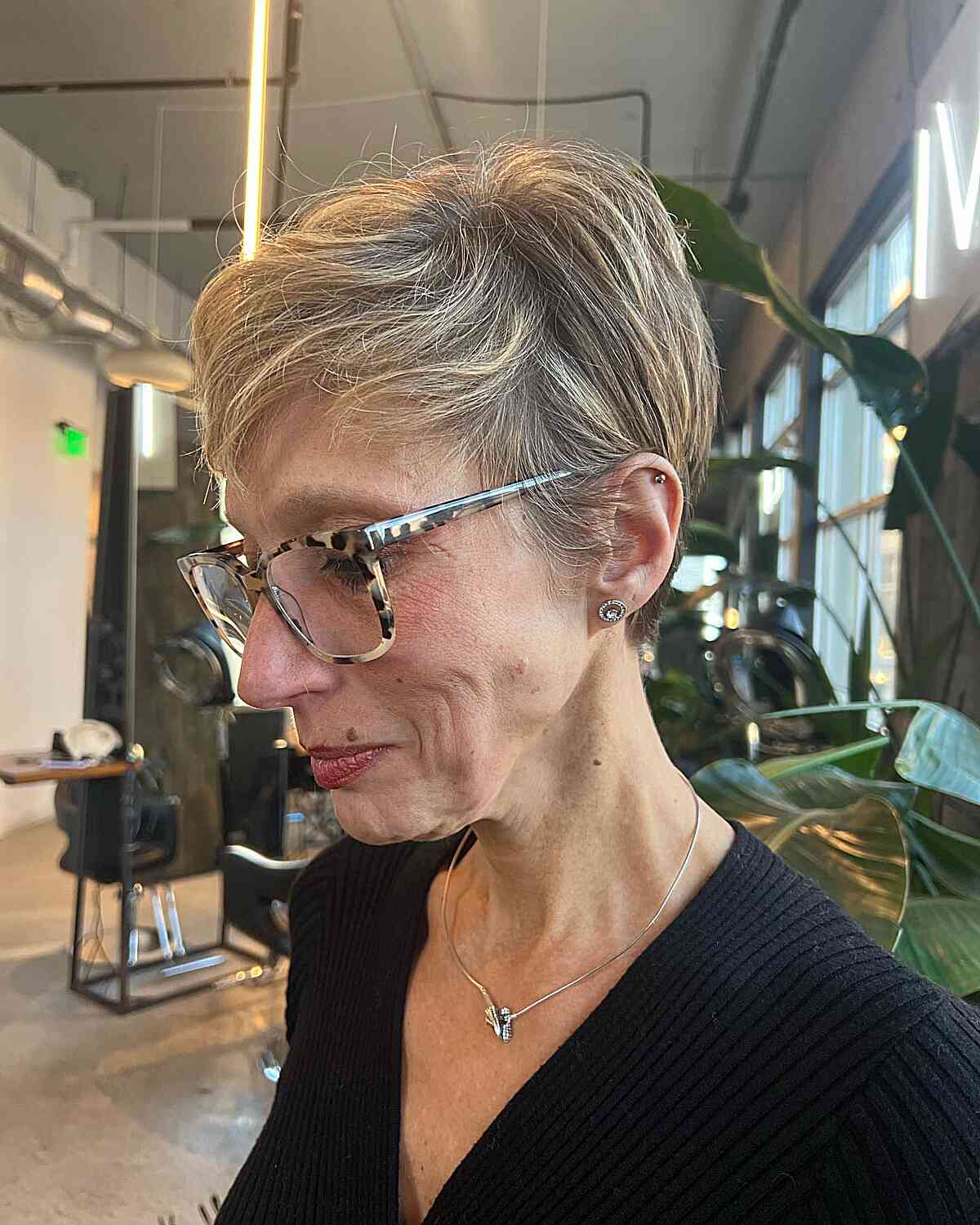 short side swept pixie with blonde highlights for women past their 60s with glasses