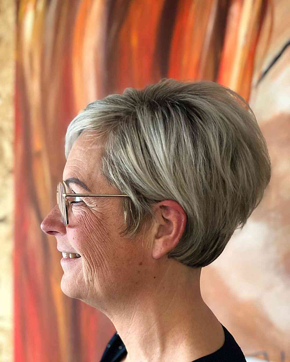 side parted stacked pixie cut for mature women over 60 wearing glasses