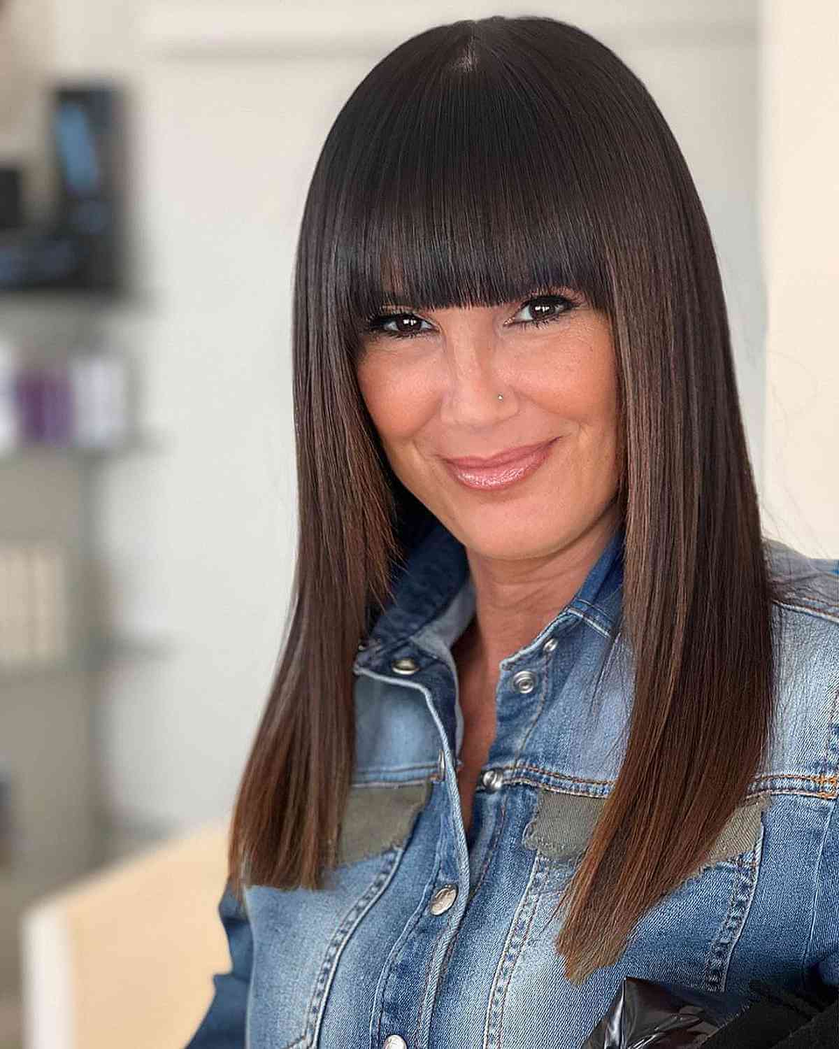 sleek extra long bob with fringe bangs for a woman over forty