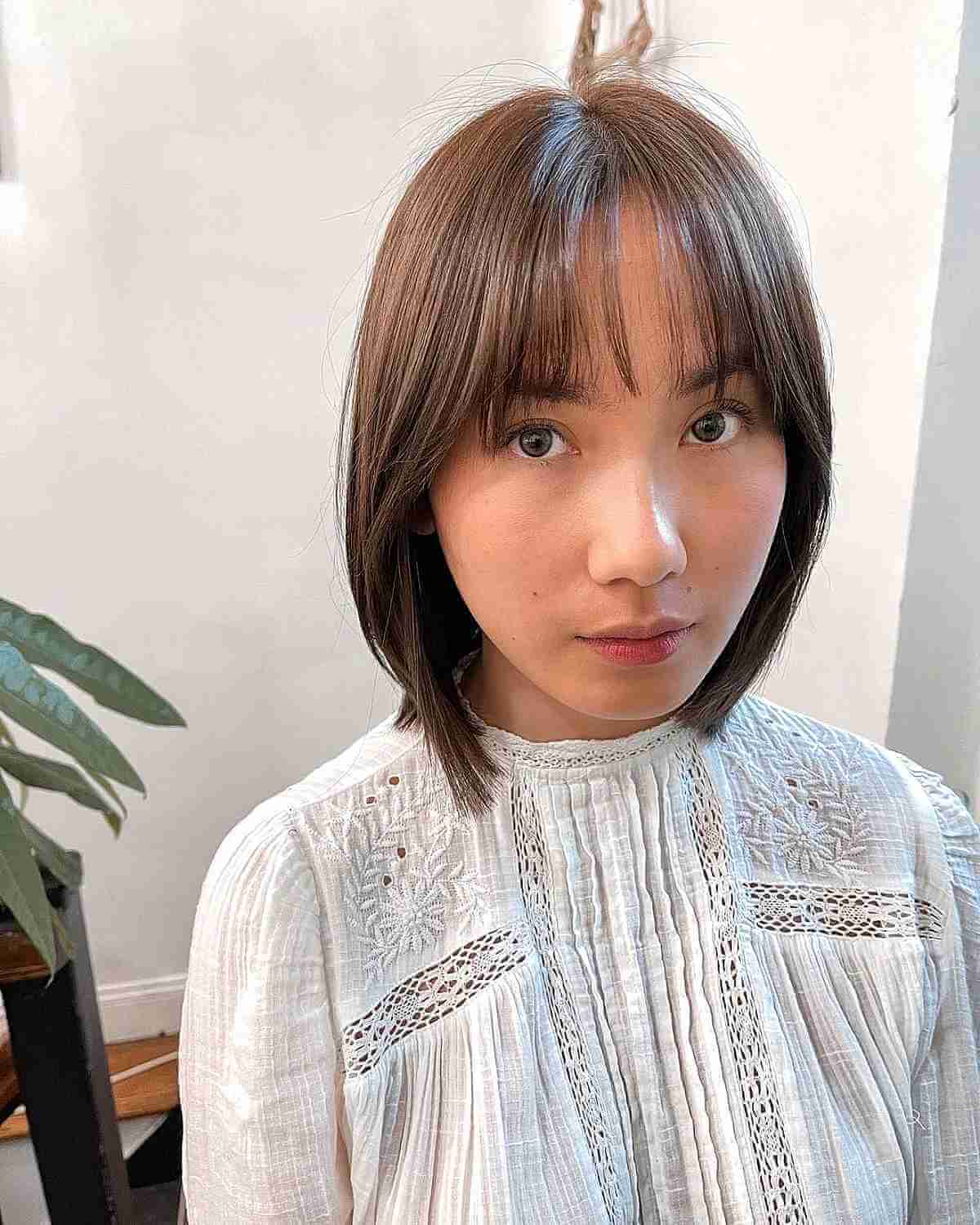 thinning brunette bob with light layers and bangs