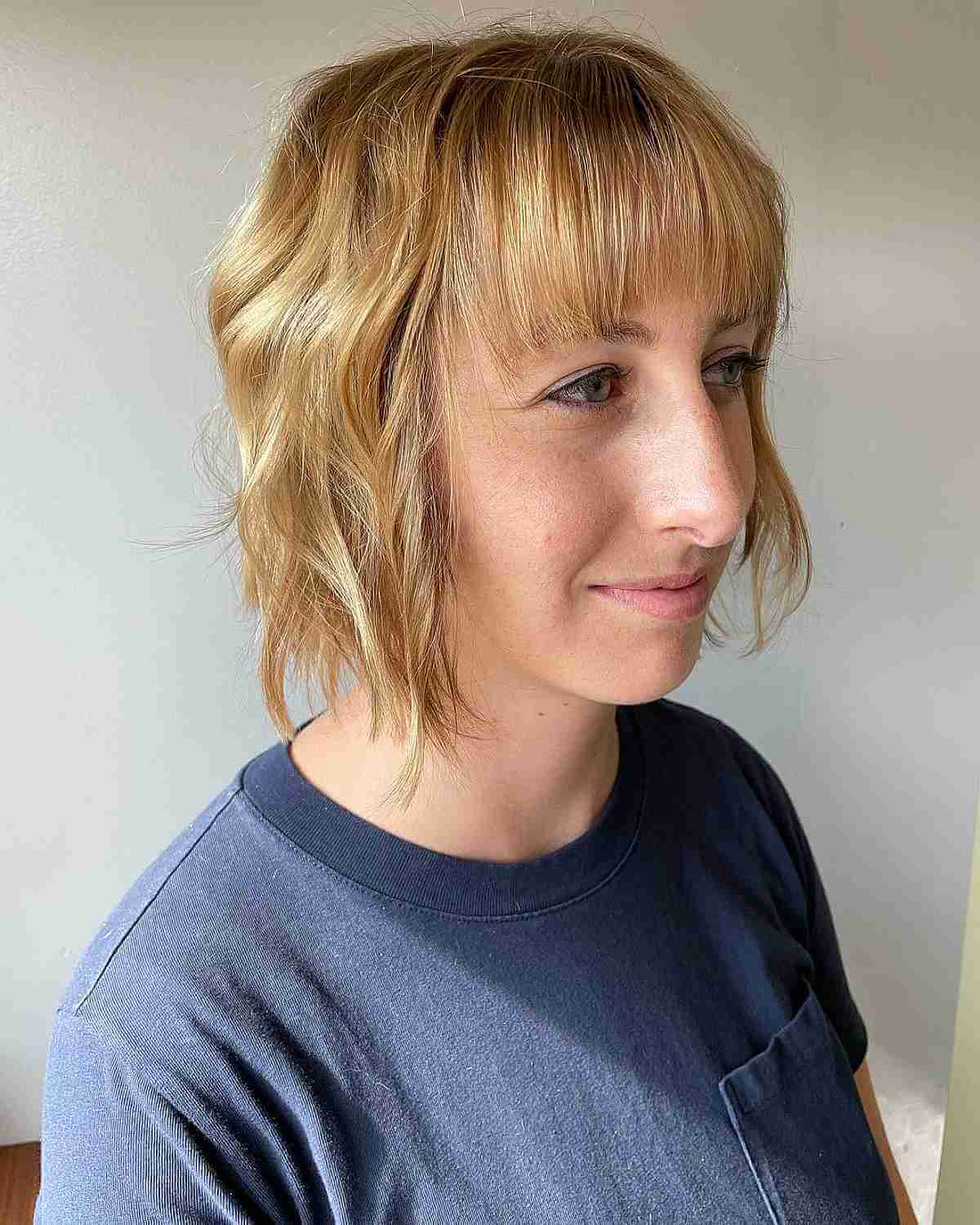 thinning tousled bob with beach waves and straight bangs